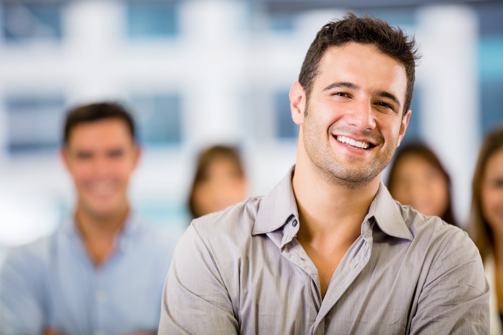 Happy business man with a group at the office